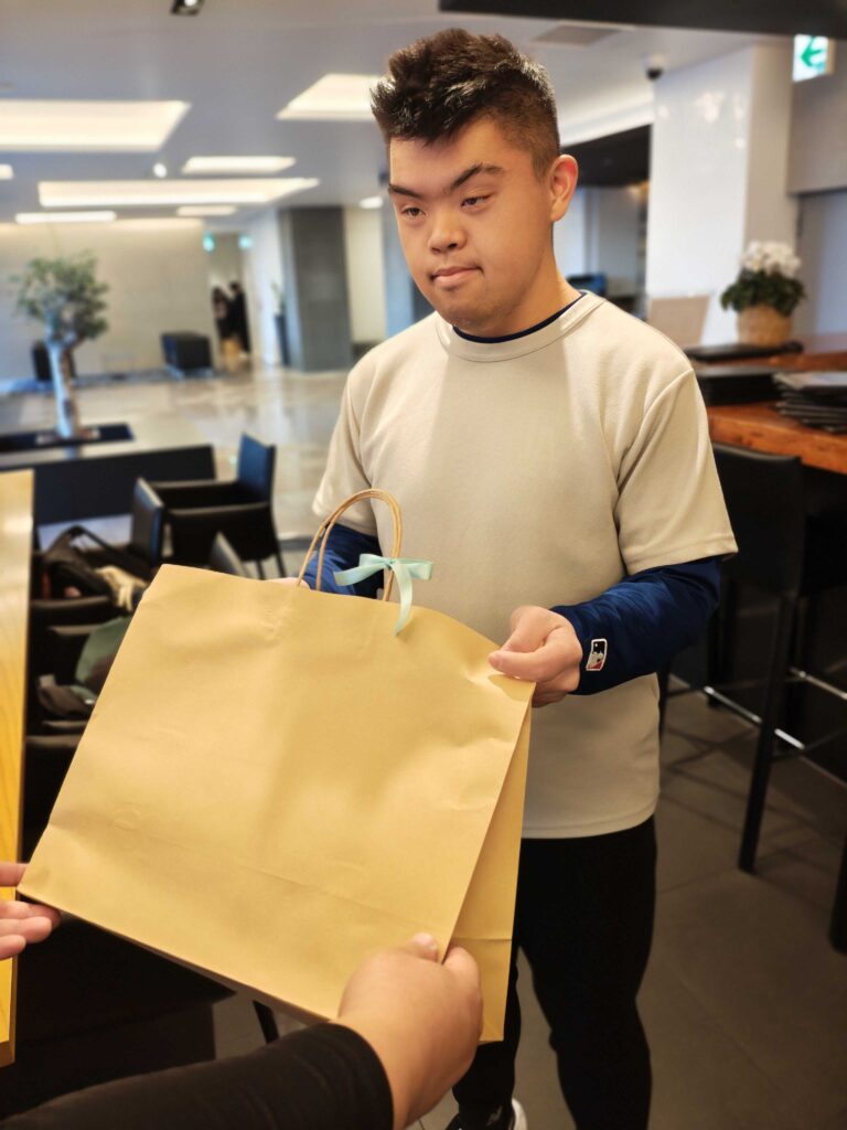 約束の樹のユニフォームを受け取る利用者さま