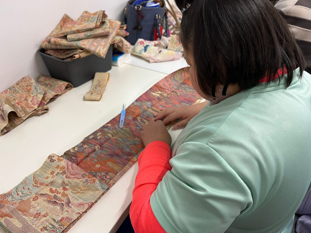 約束の樹北子安で行う着物の糸取り作業